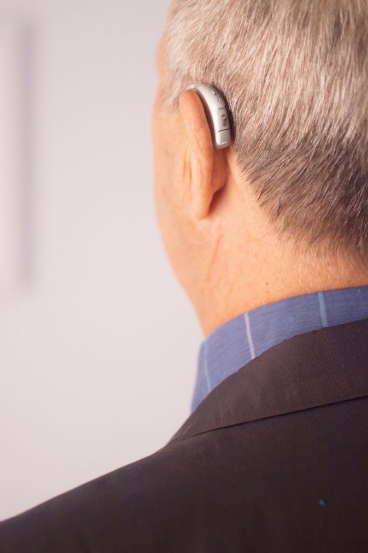 A man with a hearing aid in his left ear.