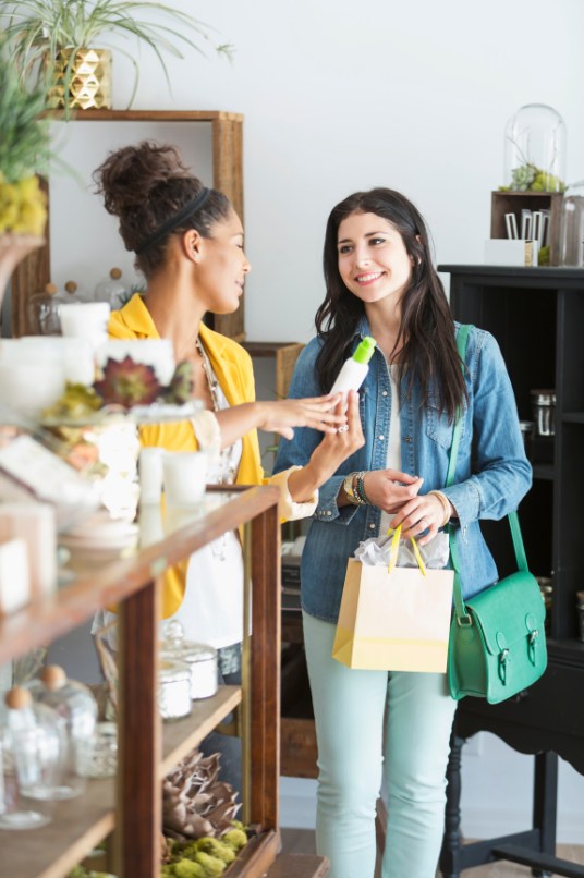 shop employee showing product to a customer in store